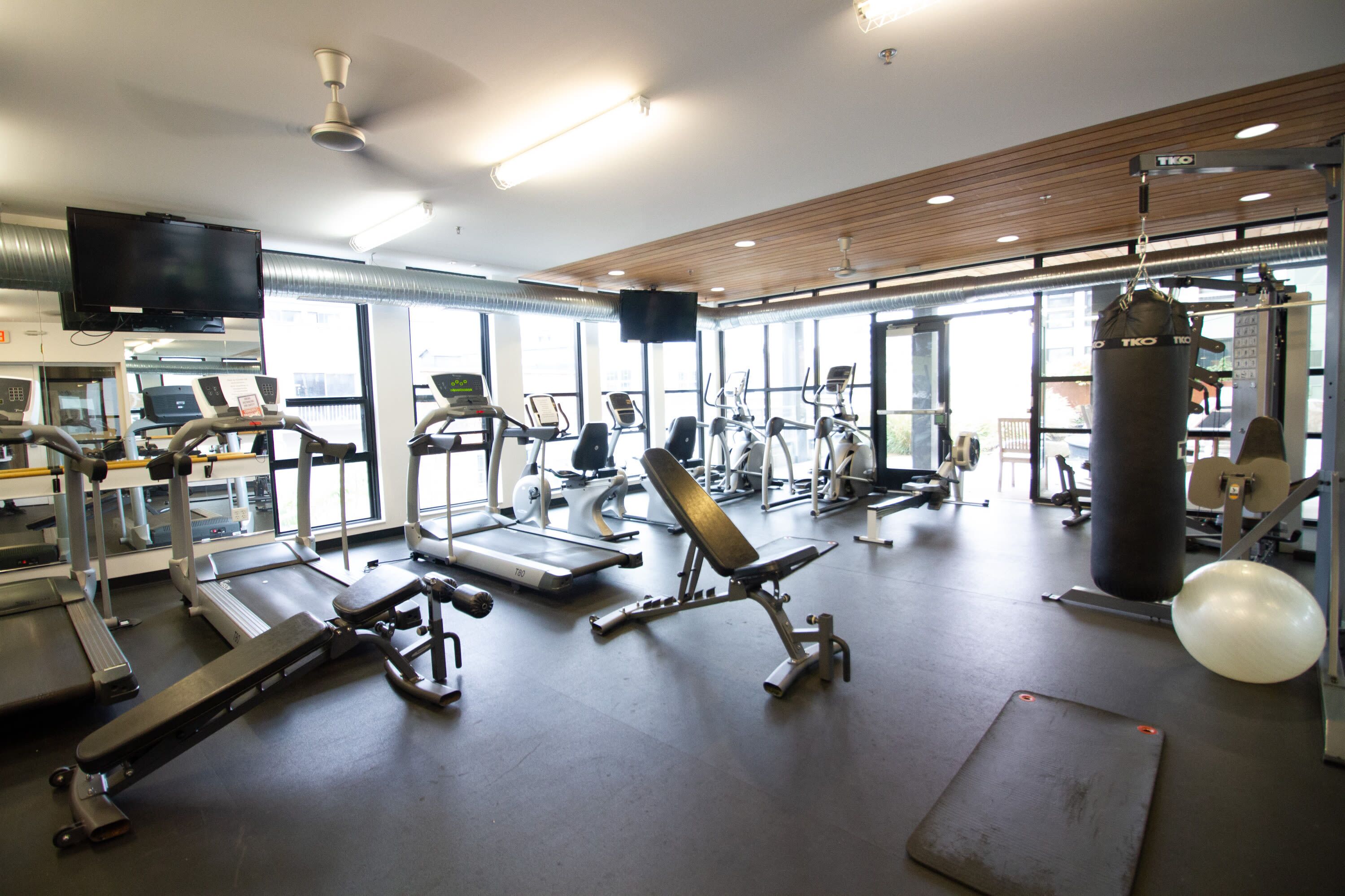 A gym with treadmills, elliptical machines, and weightlifting equipment.