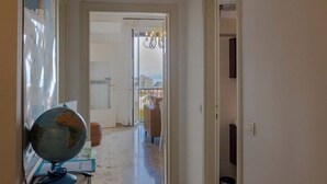 A hallway with a marble floor leading to a room with a view. - Exclusive apartment a stone's throw from the station spectacular lake view Daisy  (Desenzano del Garda)