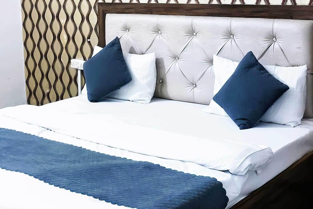 A bed with a wooden frame, white bedding, and blue accents.