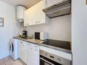 Een koelkast, een microgolfoven, een oven, kookgerei, borden en bestek