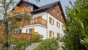 A two-story building with a balcony, wooden railings, and a stone pathway leading to the entrance. - Ferienwohnung mit Aussicht, Neuastenberg (Winterberg)