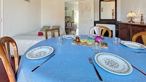 A dining room with a blue tablecloth, white plates with black patterns, and wooden chairs. - Brin de Muguet by Interhome (Tharon Plage)