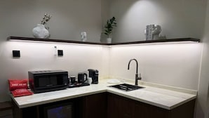 A compact kitchen with a microwave, coffee maker, and sink. A first aid kit is visible on the counter. - Luxury & Comfort in Prime Al-Qairawan Location!
Modern Design, 5G Internet (Riyadh)