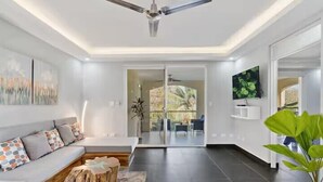 Un salon moderne avec un canapé, une table basse et une plante en pot.