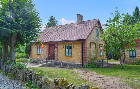 A traditional brick house with a sloped roof, a wooden door, and a small porch with steps leading to the entrance. - Nice home in Gärds Köpinge (Gärds Köpinge)