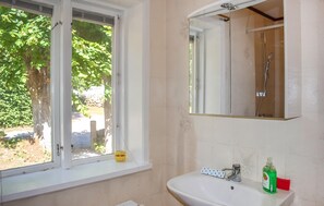 A bathroom with a window, a sink, a mirror, and a shower. - Nice home in Gärds Köpinge (Gärds Köpinge)