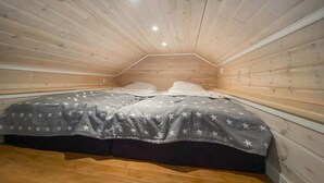 A small, cozy attic bedroom with a sloped ceiling and wooden walls. - Cozy home in Kalmar with WiFi (kalmar)