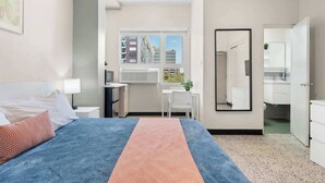 Una habitación de hotel moderna con cama, escritorio y baño.