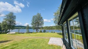 Une maison avec vue sur un lac et des arbres.