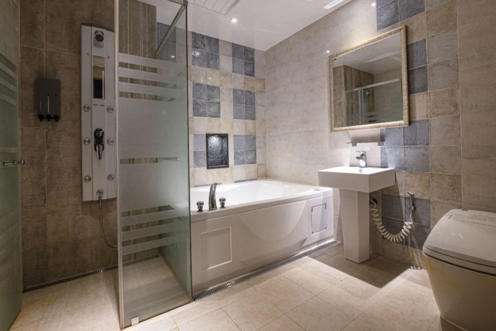 Une salle de bain moderne avec une douche à parois de verre, une baignoire sur pieds, un lavabo avec un miroir et des toilettes.