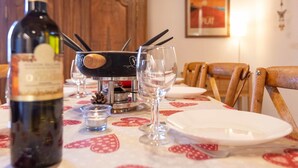 Une table à manger dressée avec des assiettes, des verres et une bouteille de vin.