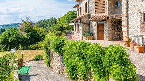A stone house with a balcony, surrounded by lush greenery and a clear sky. - Stunning  villa for 10 people with A/C, WIFI, TV, patio and panoramic view (Castellina In Chianti)