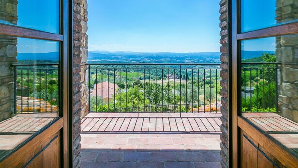 A balcony with a stone wall and wooden floor, offering a view of a green landscape and distant hills. - Stunning  villa for 10 people with A/C, WIFI, TV, patio and panoramic view (Castellina In Chianti)