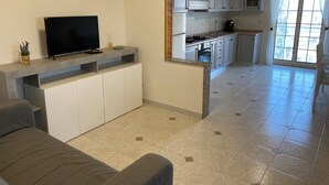Een moderne keuken met witte kasten, een inbouwoven en een aanrecht met een televisie.