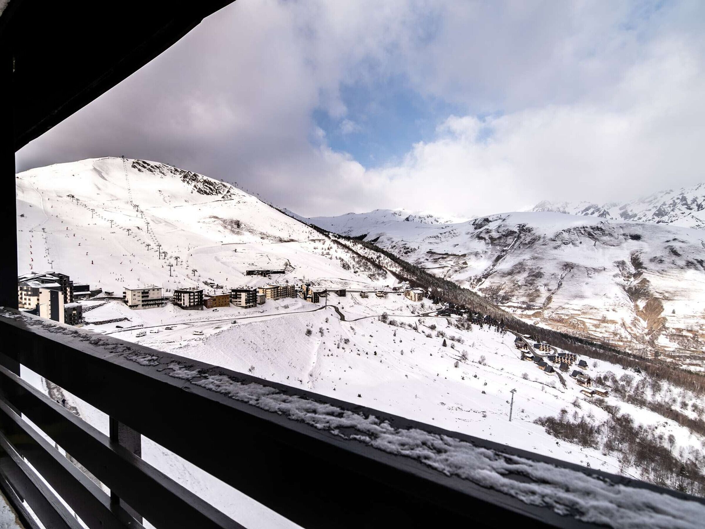 A snow-covered mountain landscape with buildings and a ski slope.
