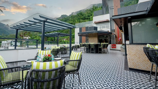 Une terrasse sur le toit avec des sièges extérieurs, un espace bar et une vue sur les montagnes environnantes.