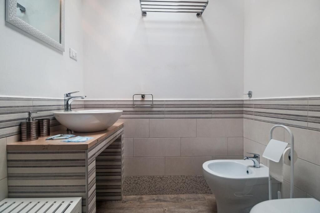 Ein Badezimmer mit einem großen Waschbecken, einem Bidet und einer Toilette.