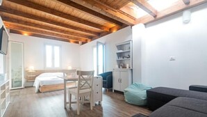 A room with a bed, a desk, a chair, a sofa, and a cabinet. - LOCANDA SU RECREU (Cala Gonone)