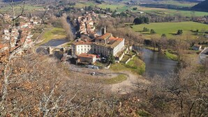 A town with a river, historic buildings, and a hilly landscape. - House for rent by the river in a peaceful hamlet (Saint-Cirgues)