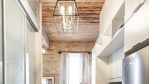 Una cocina moderna con techo de madera, electrodomésticos de acero inoxidable y una zona de estar acogedora con chimenea.