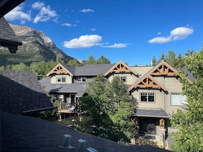 A residential area with multiple houses featuring gabled roofs and wooden accents, set against a backdrop of mountains and clear skies. - Copper Point - Outdoor Hot Tub | Fire Table | Gym (Dead Man`s Flats)