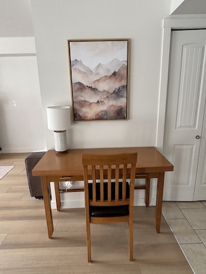 A wooden dining table with a chair, a lamp, and a framed painting on the wall. - Copper Point - Outdoor Hot Tub | Fire Table | Gym (Dead Man`s Flats)