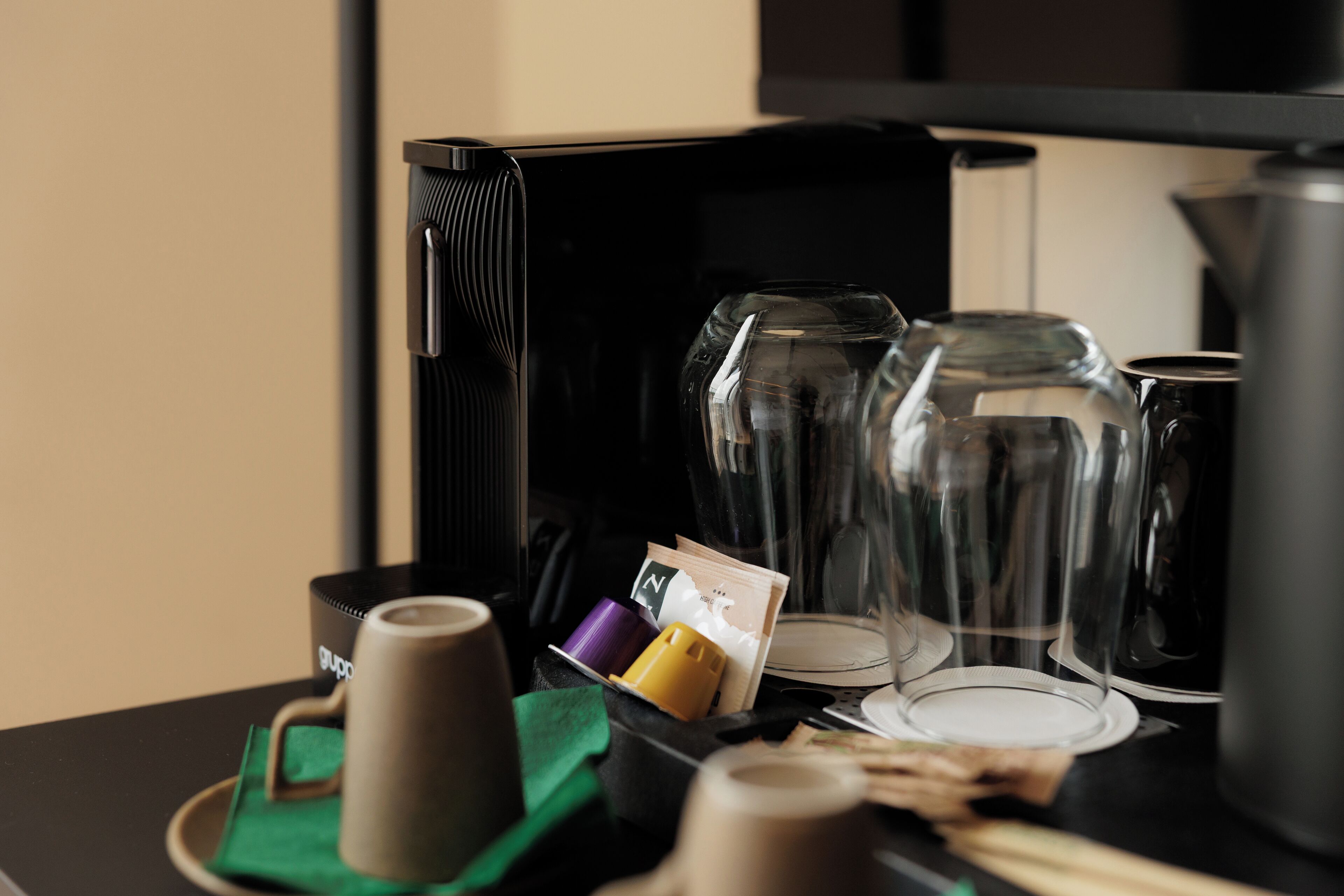 Un coin café équipé d’une machine à café, de tasses et de serviettes en papier.