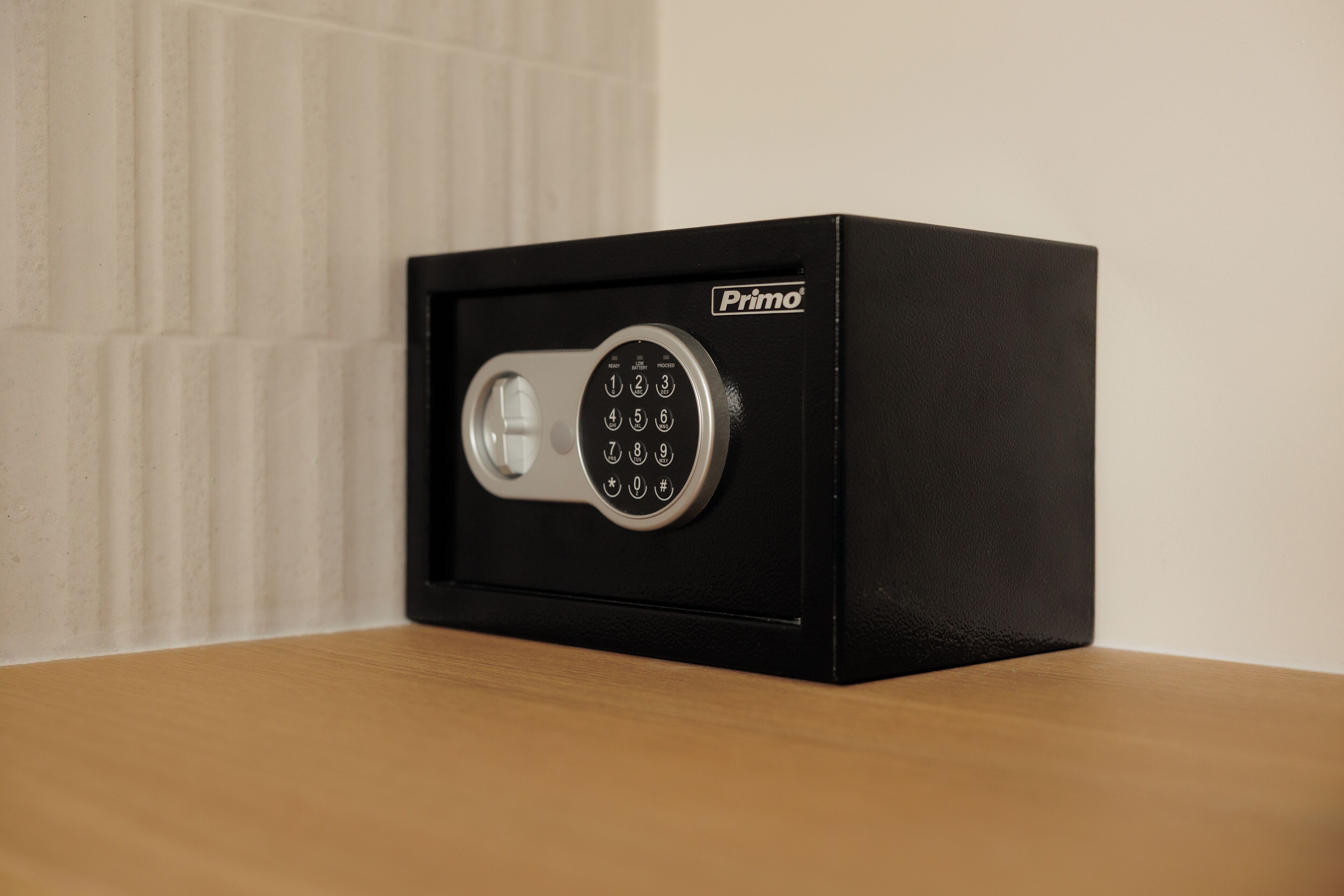 Una caja fuerte negra con cerradura electrónica y el nombre de la marca "Primo".