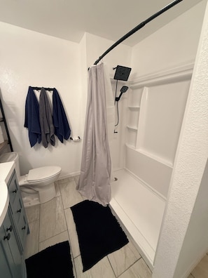 Een badkamer met toilet, douche en wastafel.