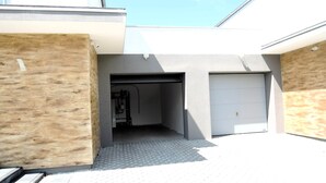 A modern building with a garage and a covered entrance. - Luxury Holiday Home for 20 People (gmina Wolin)