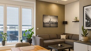 Een moderne woonkamer met een houten eettafel, een grijze bank en een stadsgezichtschilderij aan de muur.