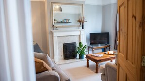 A living room with a fireplace, a television, and a sofa. - The Mount Street Townhouse (Harrogate)
