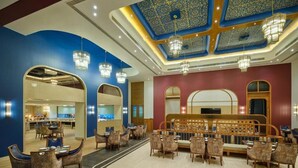 A hotel lobby with a central seating area, mirrored walls, and a decorative ceiling. - Regenta Central Shivani Solapur (Mohol)