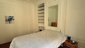 A bedroom with a bed, a nightstand, a mirror, and a radiator. - Paris 15 Beau 2 bedrooms, living room, ground floor. Wifi, net, Pets allowed. (Paris)