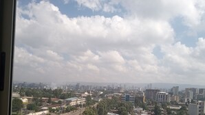 A cityscape with buildings and a cloudy sky.