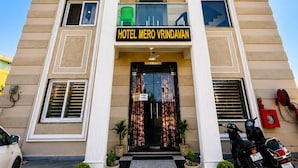 Un hôtel dont l’entrée est marquée par une enseigne bien visible portant l’inscription « HÔTEL MERO VRINDAVAN ».