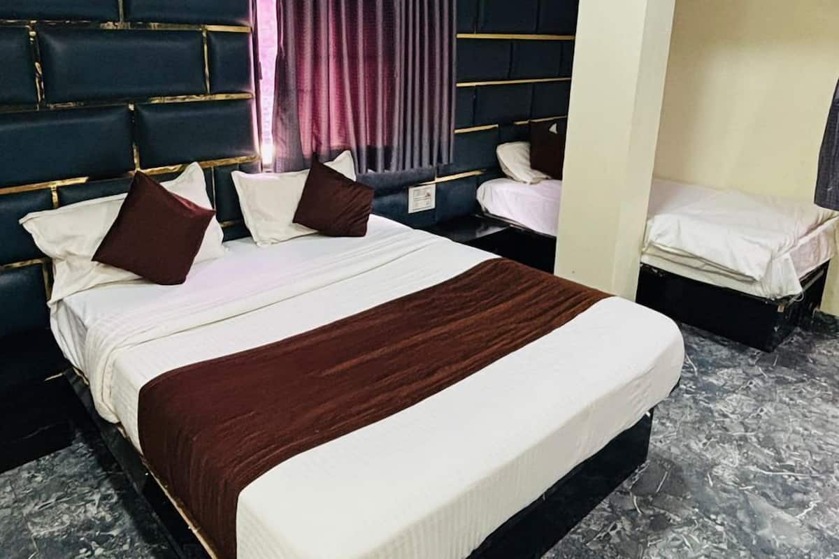 A hotel room with a large bed, a smaller bed, a headboard, a wall-mounted air conditioner, and a marble floor.