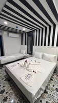 Habitación de hotel con cama, dos mesitas de noche, un espejo y aire acondicionado instalado en la pared.
