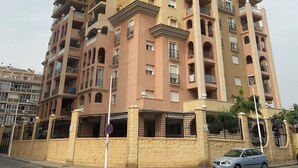 A multi-story residential building with balconies and a gated entrance. - Fabi Beach Apartment (Torrevieja) (Torrevieja)