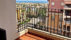 A balcony with a view of a coastal town, featuring tiled flooring and a metal railing. - Fabi Beach Apartment (Torrevieja) (Torrevieja)