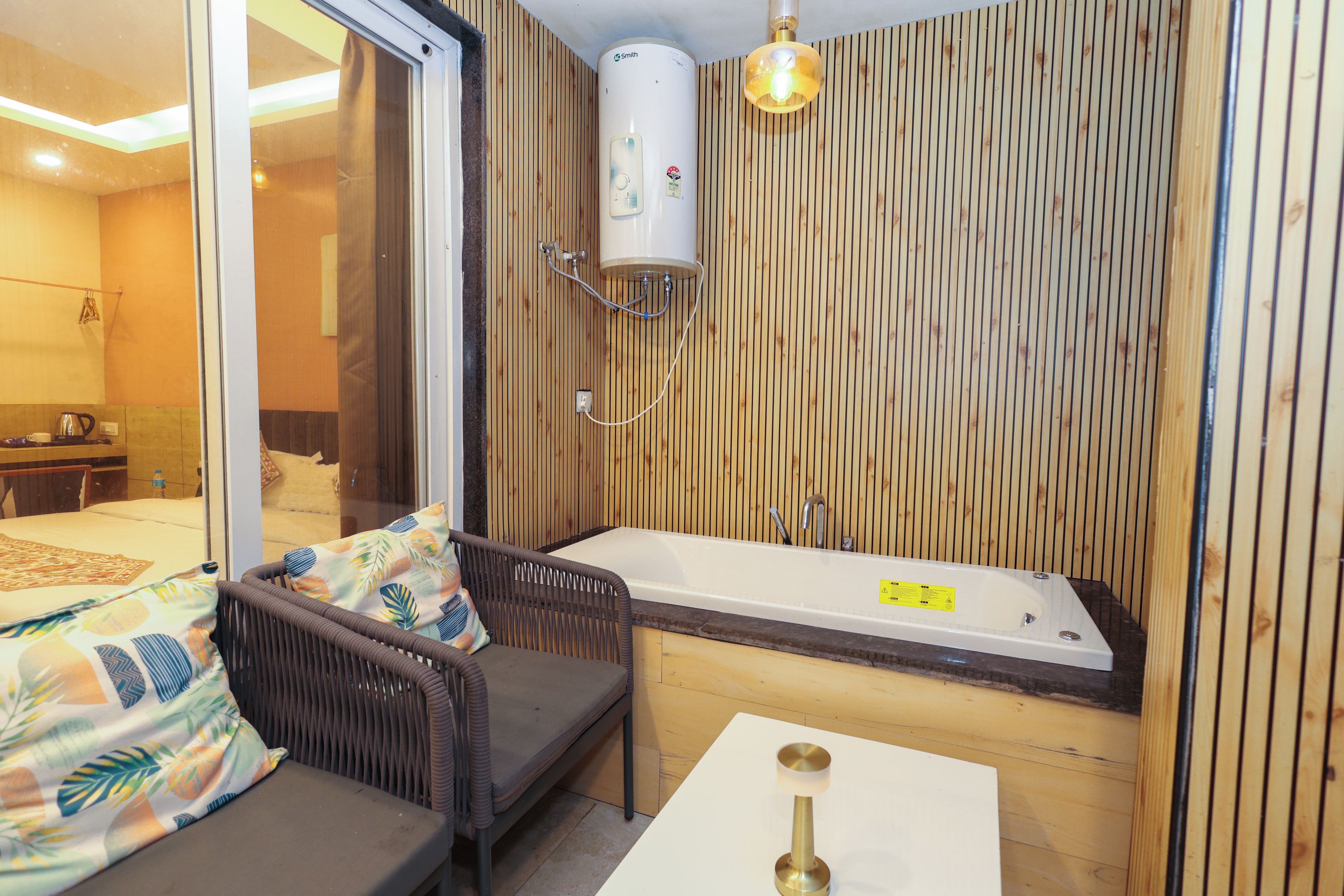 Un baño moderno con bañera, ducha y zona de estar con sofá y mesa.