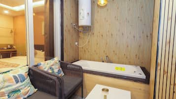 Un baño moderno con bañera, ducha y zona de estar con sofá y mesa.