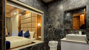 Une salle de bain moderne avec un sol en marbre, un grand miroir, un lavabo intégré et un espace douche.