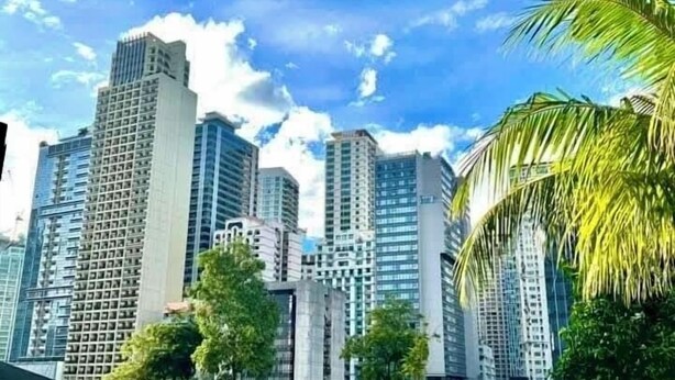A modern urban landscape with high-rise buildings, a swimming pool, and well-maintained greenery.