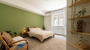 A bedroom with a bed, a chair, a bedside table with a lamp, and a window with curtains. - Just minutes from downtown and the beach, elegant BnB in Sirolo (Sirolo)