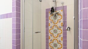 A shower with a glass door, purple and white tiles, and a decorative tile pattern on the wall. - Just minutes from downtown and the beach, elegant BnB in Sirolo (Sirolo)