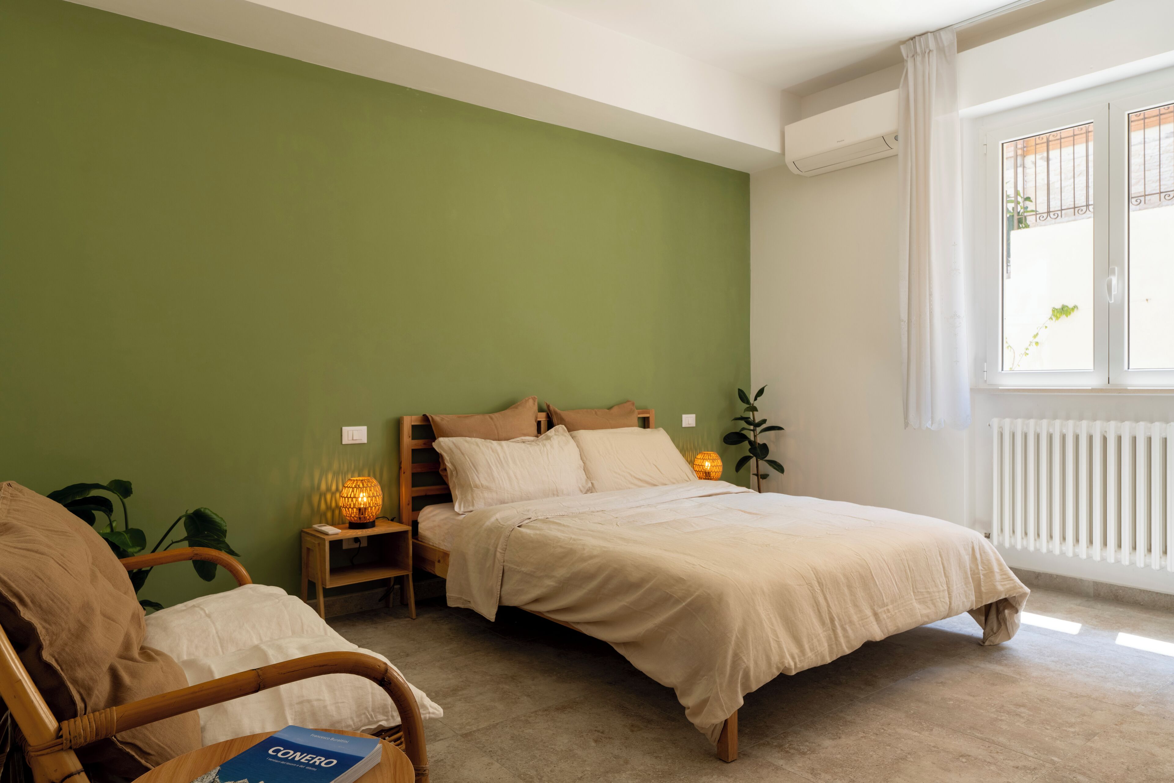 A bedroom with a bed, bedside tables, a chair, and a window with curtains.