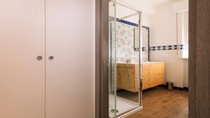 A bathroom with a wooden vanity, a glass shower enclosure, and a tiled backsplash. - ~The Cirrus Guesthouse~ (Sirolo)