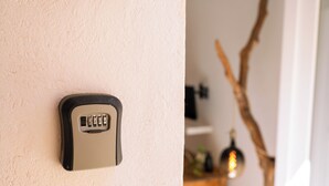 A wall-mounted electronic keypad lock. - ~The Cirrus Guesthouse~ (Sirolo)