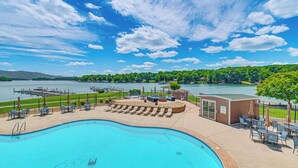 A swimming pool with lounge chairs and a view of a lake. - Steps to Smith Mountain Lake: Unit w/ Pool Access! (Huddleston)